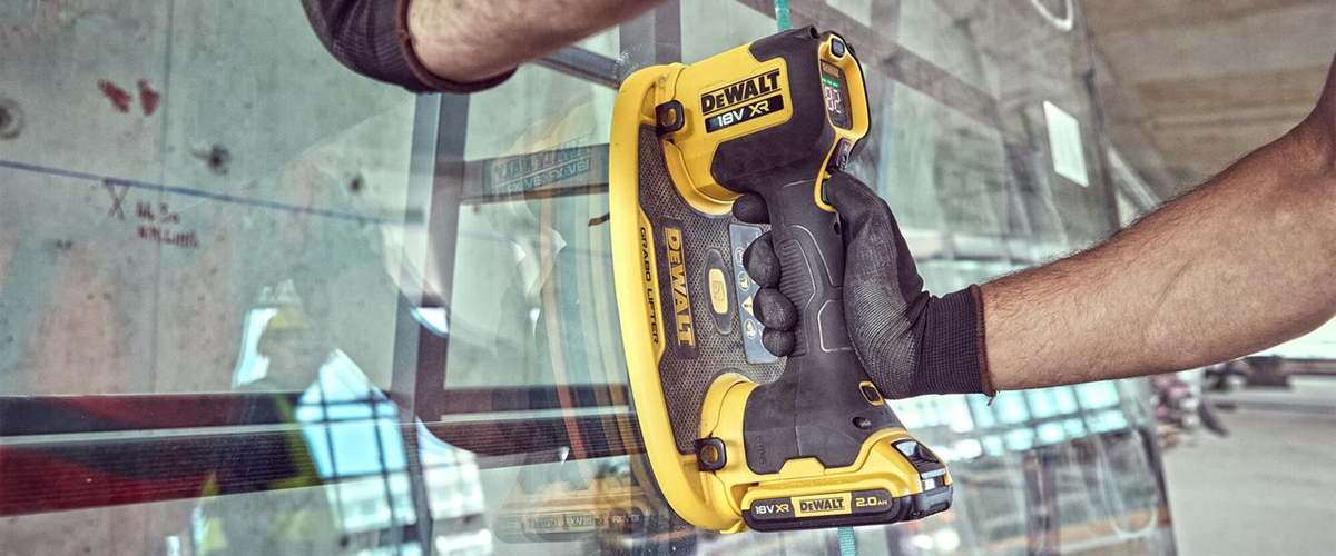 Operaio usa sollevatore a vuoto DeWALT per spostare lastra di vetro in cantiere Lecco